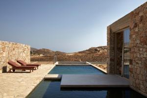a swimming pool in the middle of a house at Perma Serifos in Serifos Chora