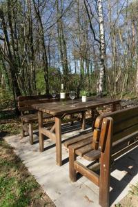 una mesa de picnic de madera con copas de vino. en Haus Im Wiesengrund EG, en Thalfang
