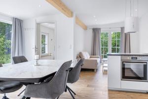 PutgartenにあるFerienhaus zum Nordstrandのテーブルと椅子のあるキッチンとダイニングルーム