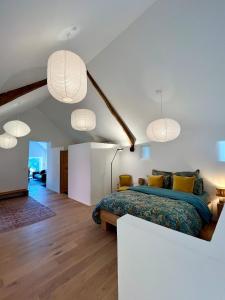 a bedroom with a bed and three pendant lights at Eschette Retreat in Rambrouch