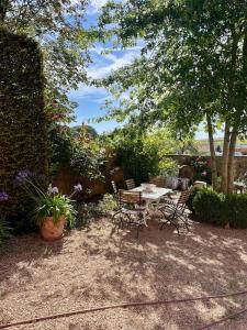 a patio with a table and chairs and flowers at Eschette Retreat in Rambrouch