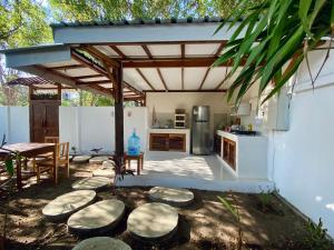 a patio with a kitchen and a table and a counter at Gaia cottages in Gili Trawangan