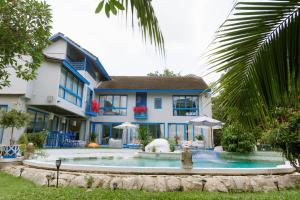 ein Haus mit einem Swimmingpool davor in der Unterkunft Sheva Om in Ban Wat Pho Thong