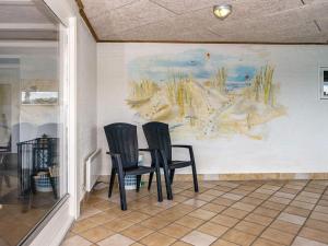 due sedie sedute davanti a un dipinto su una parete di 8 person holiday home in Ringkøbing-By Traum a Ringkøbing