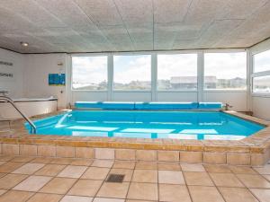 una grande piscina in una stanza con finestre di 8 person holiday home in Ringkøbing-By Traum a Ringkøbing