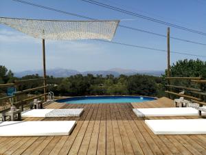 - une piscine sur une terrasse en bois avec des chaises dans l'établissement Son Aloui Mallorca, à Llubí
