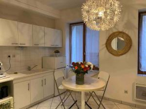 een keuken met een tafel met daarop een vaas met bloemen bij Oasis - City Center in Annecy