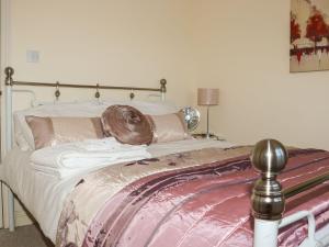 a bed with pink and white sheets and pillows at Atlantic View in Bude