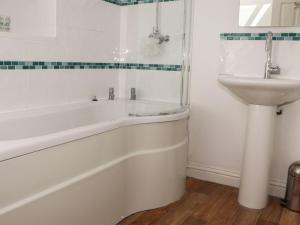 a bathroom with a bath tub and a sink at Atlantic View in Bude +11 photos
