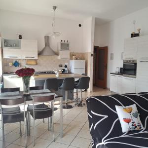a kitchen and living room with a table and chairs at La Casa di Ale 2 - ampio e luminoso appartamento ai Castelli Romani in Marino