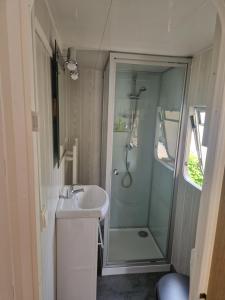 カンボ・レ・バンにあるMon Petit Mobil Homeのシャワーと洗面台付きのバスルーム