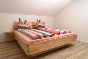 a bed with pillows on it in a room at Ferienhaus Waldklause in Schwarzenberg