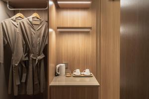 a bathroom with a closet with a robe and shoes at Nola Hotel in Ho Chi Minh City