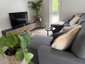 a living room with a couch and a tv at Wilhelmines Hafenliebe am Park mit Balkon, Netflix, & Privatparkplatz in Wilhelmshaven