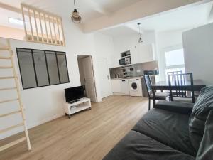 sala de estar con sofá y TV y cocina en Salmon paix avec accès autonome, en Villejuif