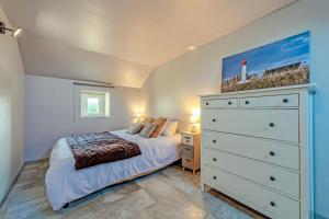 una camera con letto bianco e cassettiera di Longère de charme - jardin et spa a Plougonvelin