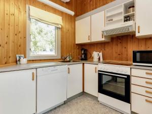 eine Küche mit weißen Schränken und einem Fenster in der Unterkunft 6 person holiday home in Gedser-By Traum in Gedser + 19 Fotos