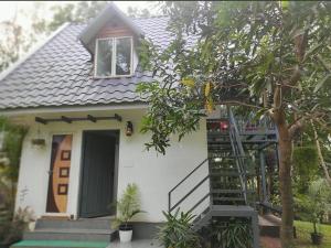 a small white house with a ladder in front of it at Poomala Holiday Village in Mulagunnathukāvu