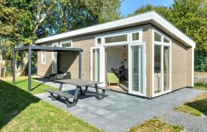 a small shed with a picnic table and a patio at Lovely Home In Heinkenszand With Heated Swimming Pool in Heinkensand