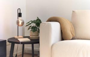 a living room with a couch and a table with a plant at Lovely Home In Heinkenszand With Heated Swimming Pool in Heinkensand
