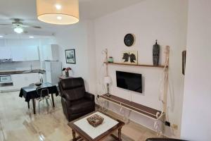 a living room with a television and a chair and a table at Apartamento Calle Real in Martos