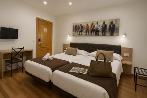 a hotel room with two beds and a television at Catedral Boutique in Seville