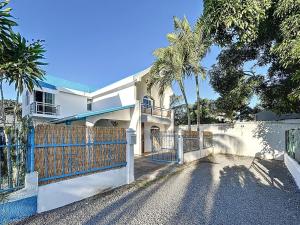 ペレベールにあるVilla Melissa Pereybere beachの塀とヤシの木がある白い家