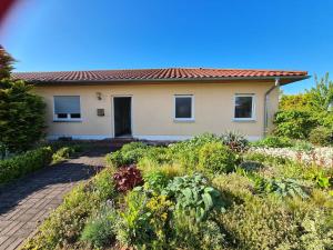ein Haus mit einem Garten davor in der Unterkunft Zimmer in Ferienwohnung Bühler in Karsdorf