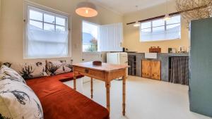 a living room with a wooden table and a kitchen at Poplar Karoo Escape in Prince Albert