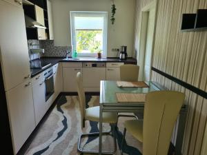 a kitchen with a table and chairs and a window at Zimmer in Ferienwohnung Bühler in Karsdorf