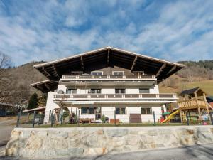 a large white building with a roof at Apartment in Bramberg near Ski Lift in Bramberg am Wildkogel +25 photos