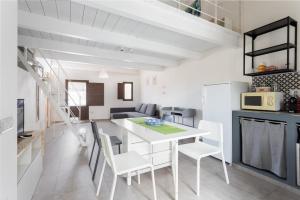 a kitchen and dining room with a white table and chairs at Il Sole di Cabras-Modern apt in the Heart of Town in Càbras