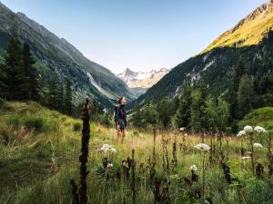 a woman standing in a field with mountains in the background at Apartment in Bramberg near Ski Lift in Bramberg am Wildkogel