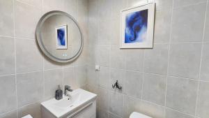 a white bathroom with a sink and a mirror at Apartament Bursztynowy Jantar 2 pokojowy z ogrodzonym tarasem przy nadmorskim lesie in Jantar +28 photos