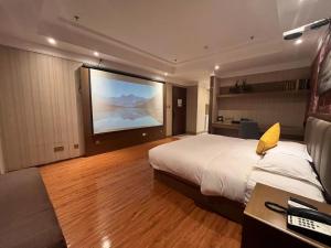 a hotel room with a large bed and a flat screen tv at Home Inn Paibaiyun Hotel Beijing Changying Subway Station Chaoyang Hospital East Branch in Beijing