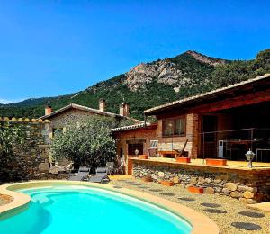 a house with a swimming pool in front of a house at Can Santalo in Cantallops