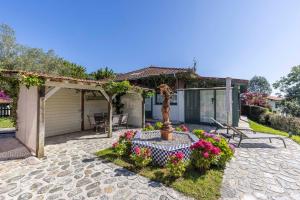 a garden with a fountain and flowers in front of a house at Apartamentos del Norte in Andrín