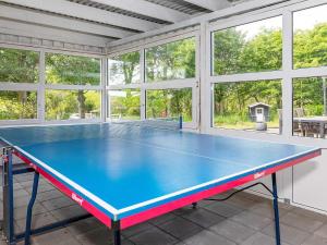 a ping pong table in a room with windows at 19 person holiday home in Løgstør-By Traum in Trend