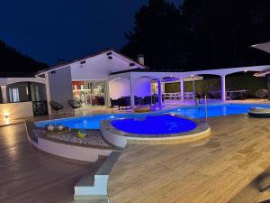 a swimming pool in front of a house at night at Villa Sany:10 Pers Maison 200m2 piscine , jacuzzi in Narrosse +74 photos