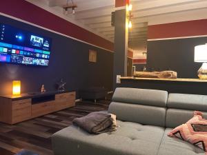 a living room with a couch and a flat screen tv at Rhin Quartier Ferienwohnung Loft-Style in Rheinsberg