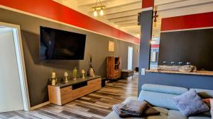a living room with a couch and a flat screen tv at RhinQuartier FeWo Loft-Style in Rheinsberg