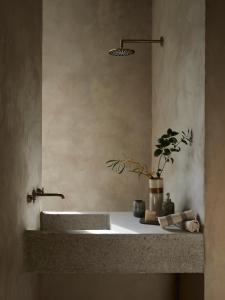 a bathroom with a sink and a vase on a counter at Perma Serifos in Serifos Chora
