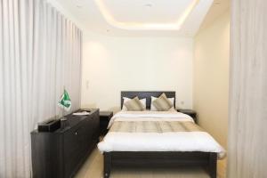 利雅德استديو داخل بناية حي النرجس的一间卧室配有一张大床和黑色梳妆台