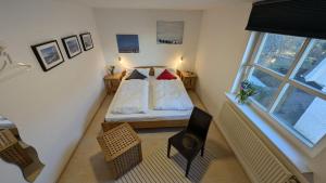 a small bedroom with a bed and a window at am-hoeben in Fehmarn