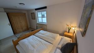 a bedroom with a bed and a window at am-hoeben in Fehmarn