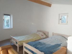 a bedroom with two twin beds in a room at Maison charmante à Saint-Siffret + Piscine in Saint-Siffret
