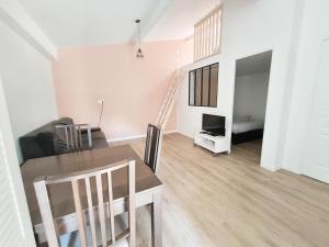Una sala de estar con mesa de comedor y una sala de estar con escalera. en Salmon paix avec accès autonome, en Villejuif