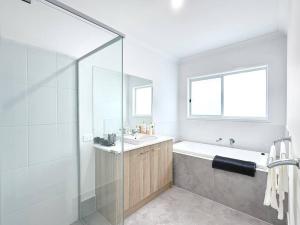 a bathroom with a tub and a sink and a shower at Home Blanc - Brand New, Peaceful & Well Equipped in Ripley