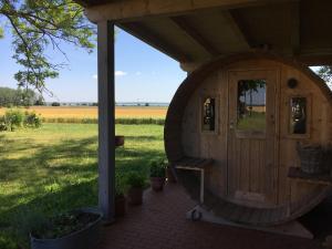 a wooden cabin with a door and a field at Ferienwohnung Gurvitz in Rambin