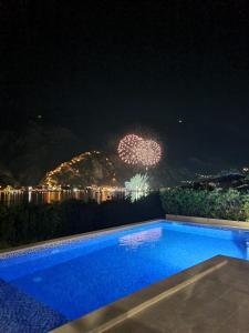 コトルにあるStudio apartment with heated poolの花火を背景にした夜のスイミングプール